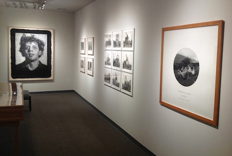 A wall with multiple size photographs on it for exhibit