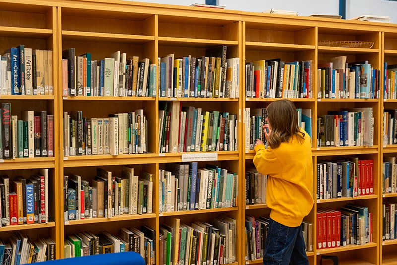 bookcase with student Marywood Announces New Programs