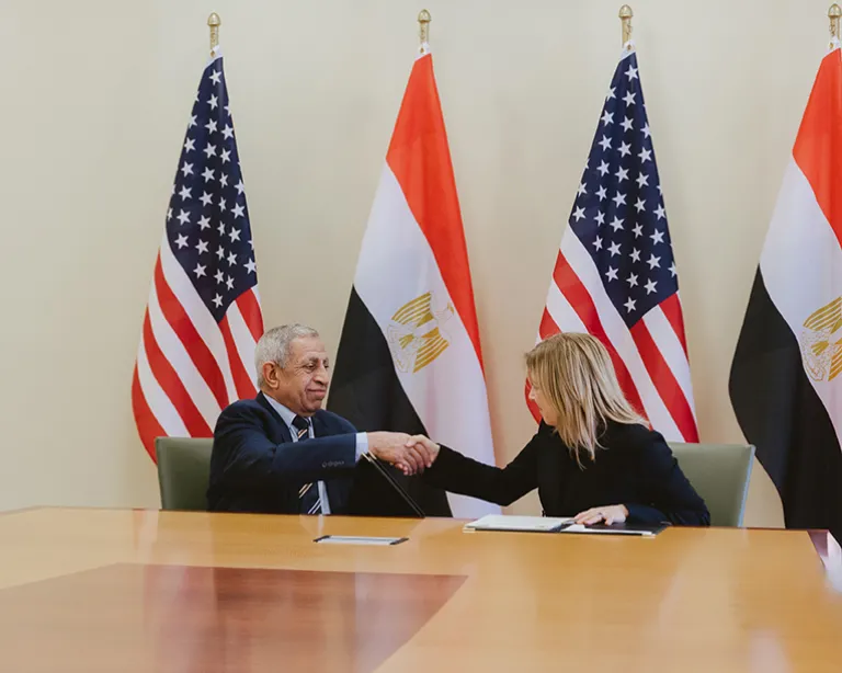 people standing in front of flags for a photo