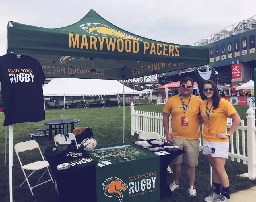 Brielle Mayle standing at Marywood Ruby Tent with Coach