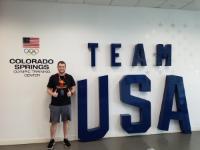 Nick Macano pictured next to a Team USA sign. Exercise Science Student Attends Team USA Symposium
