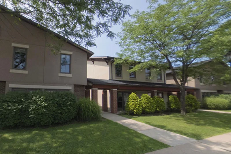 The woodlands apartments with red and green bushes in front