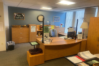 The inside of the student health services with a wooden desk in the middle and wooden cabinets on along the wall