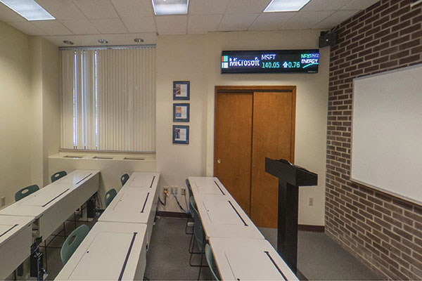 A classroom with the stock market displayed on the wall
