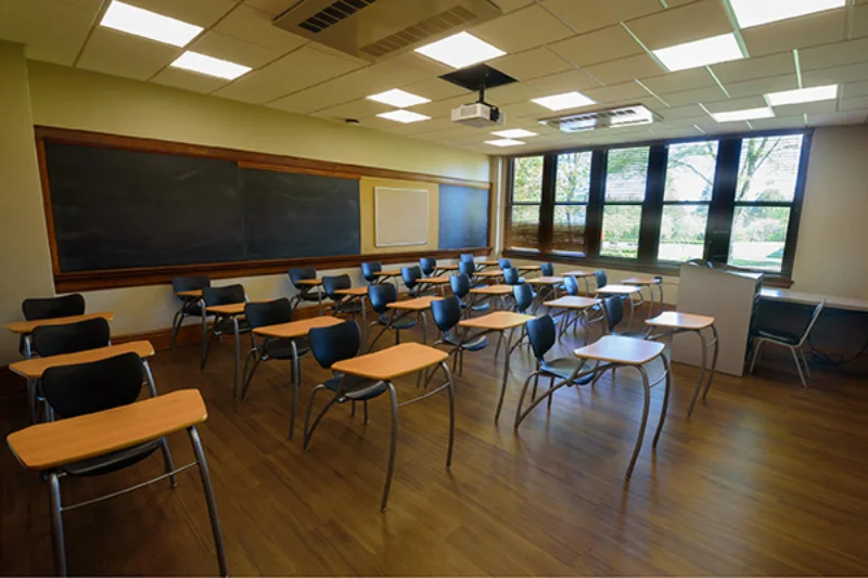 A classroom with student chair desks filling the room and a chalkboard on the wall in the Liberal Arts Center