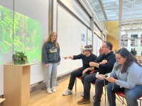 Student presents virtual project while professor wearing virtual reality headset points to the student's project. Game Design Degree: Launch Your Creative Career at Top U.S. Schools Today