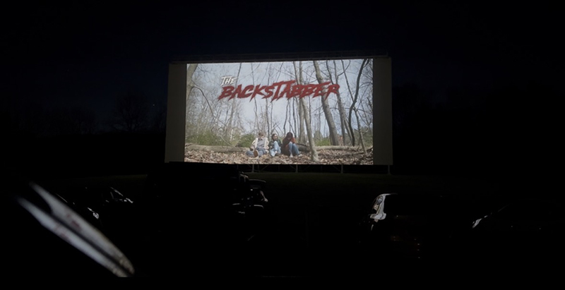 dark enviornment with a screen with the word backstabber on it