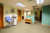 Green walls inside the Marywood Financial aid office with a Marywood logo on the wall