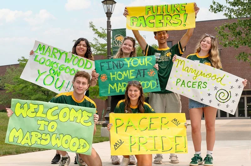 Students holding colorful green and yellow signs with Pacer Pride and Welcome to Marywood on them. Marywood University Earns Strong National and Statewide Rankings from Niche