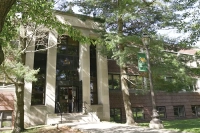 The front of the science center with a Marywood banner on the lightpole in front of it and multiple trees surrounding the building