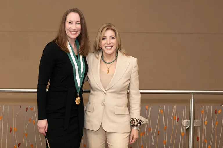 two ladies standing one with a medal around her