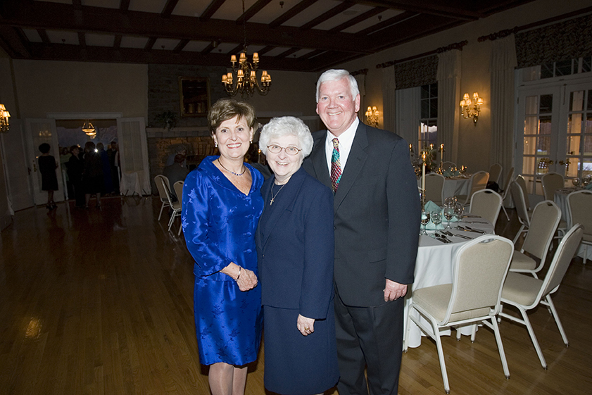 man with two women dressed nicely smiling for photo