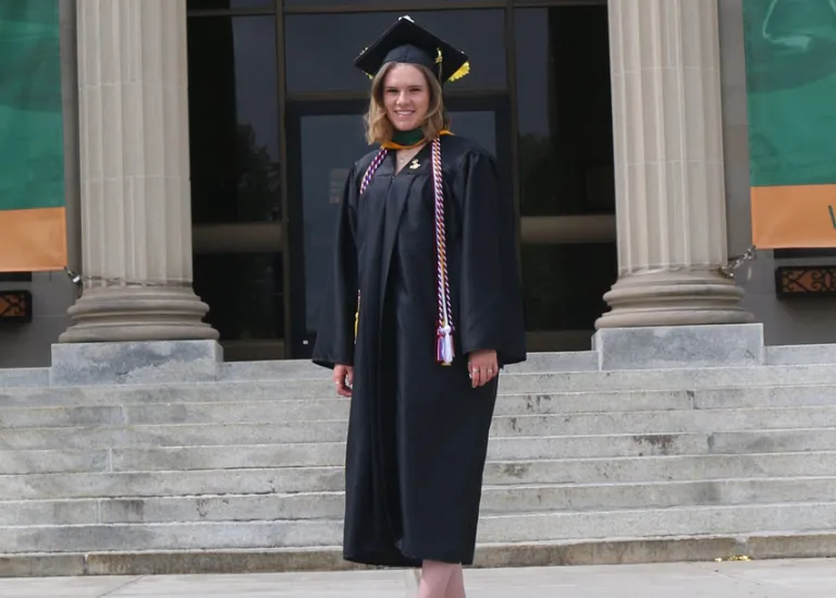 Abigail Lovatt in graduate attire on steps of the Marywood Liberal Arts Center