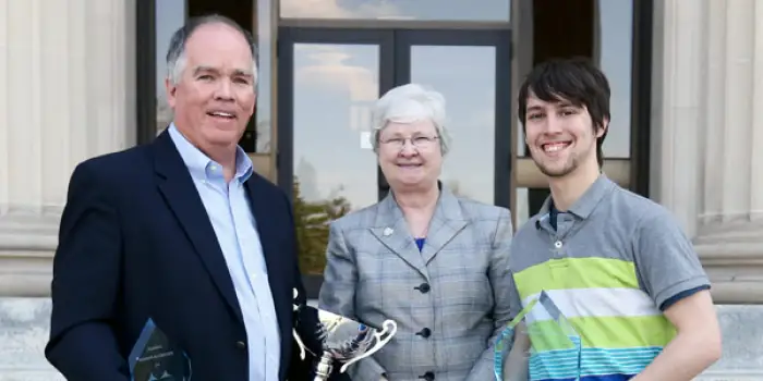 three people standing together looking forward at the camera