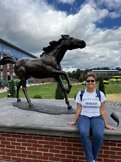 headshot of henrietta jackson, a Marywood student, next to a pacer statue