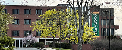 The front of Loughran hall with a Marywood banner and colorful trees