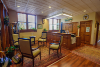 The Marywood president's office with a large wooden desk, four chairs in a square shape, Marywood-related objects on the wall