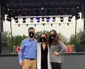 Three Marywood students in front of CNN's Joe Biden Town Hall stage at PNC field