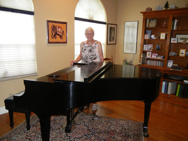 A photo of Valerie Garofalo standing behind a piano.
