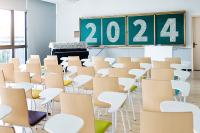 The back view of an empty classroom with 2024 written on the chalkboard.