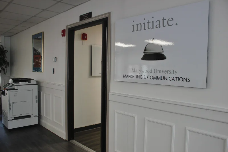 A view of the neon walls of the Marketing Office from outside the door