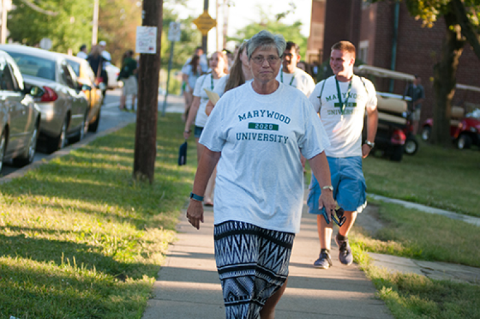 Sister Mary Persico walk on sidewalk toward camera with students Letter to the Class of 2020