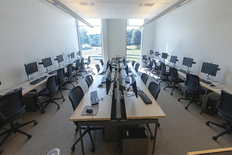 The computer lab with four rows of desks and computers
