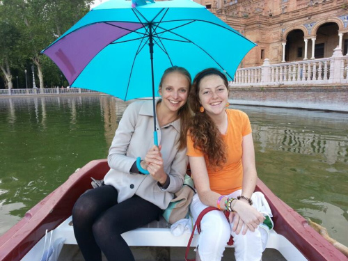 two female students in Sevilla with umbrella on boat Study Abroad Stories from Foreign Language Students
