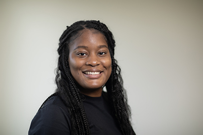 womans headshot with trees and building in background