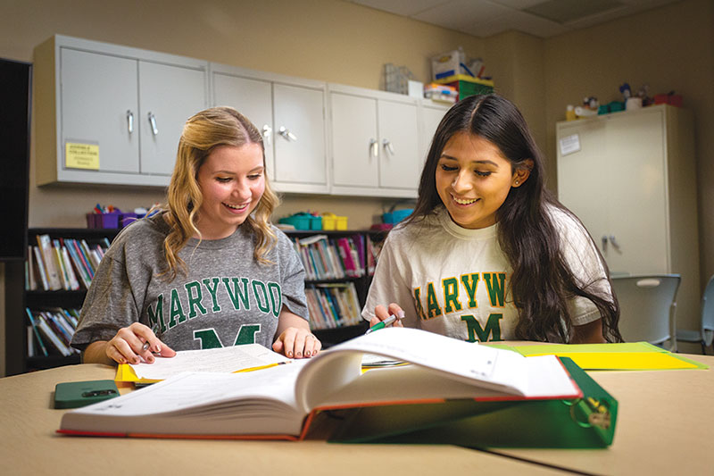 Two students with Marywood shirts studying together