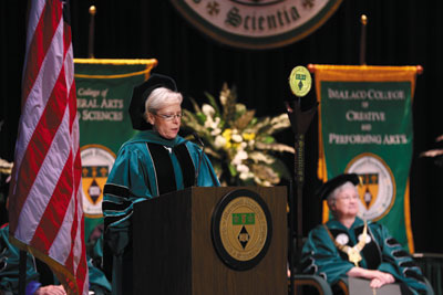 a person wearing doctorate regalia is standing in front of a podium