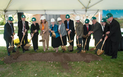 a group of people wearing suits, hardhats, and shovels standing together for a picture
