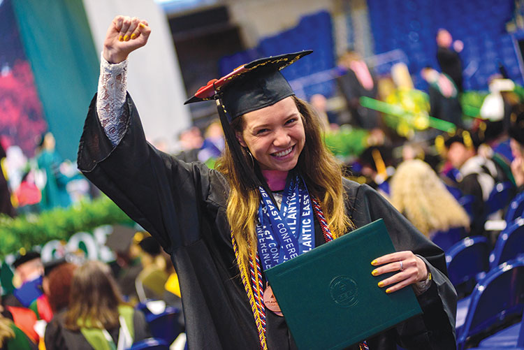 A Marywood student proudly raises their fist after graduating