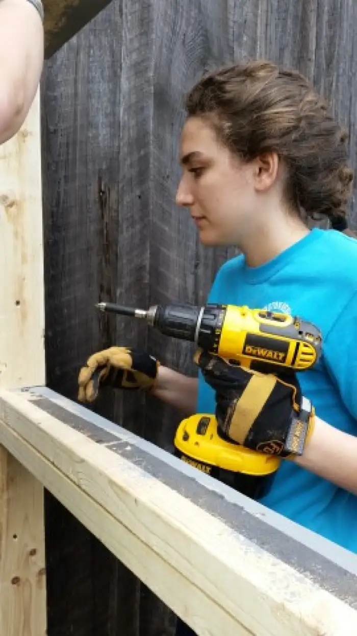 an architecture student wearing a blue shirt holding power drill
