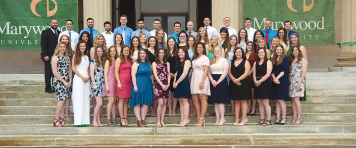 Marywood physician assistant graduates and their professors posing for a photo on the Liberal Arts Center stairs